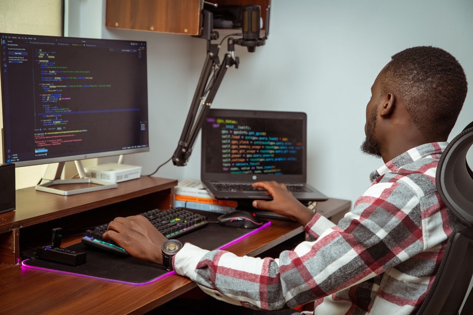 A software developer coding at a dual-monitor desk setup
