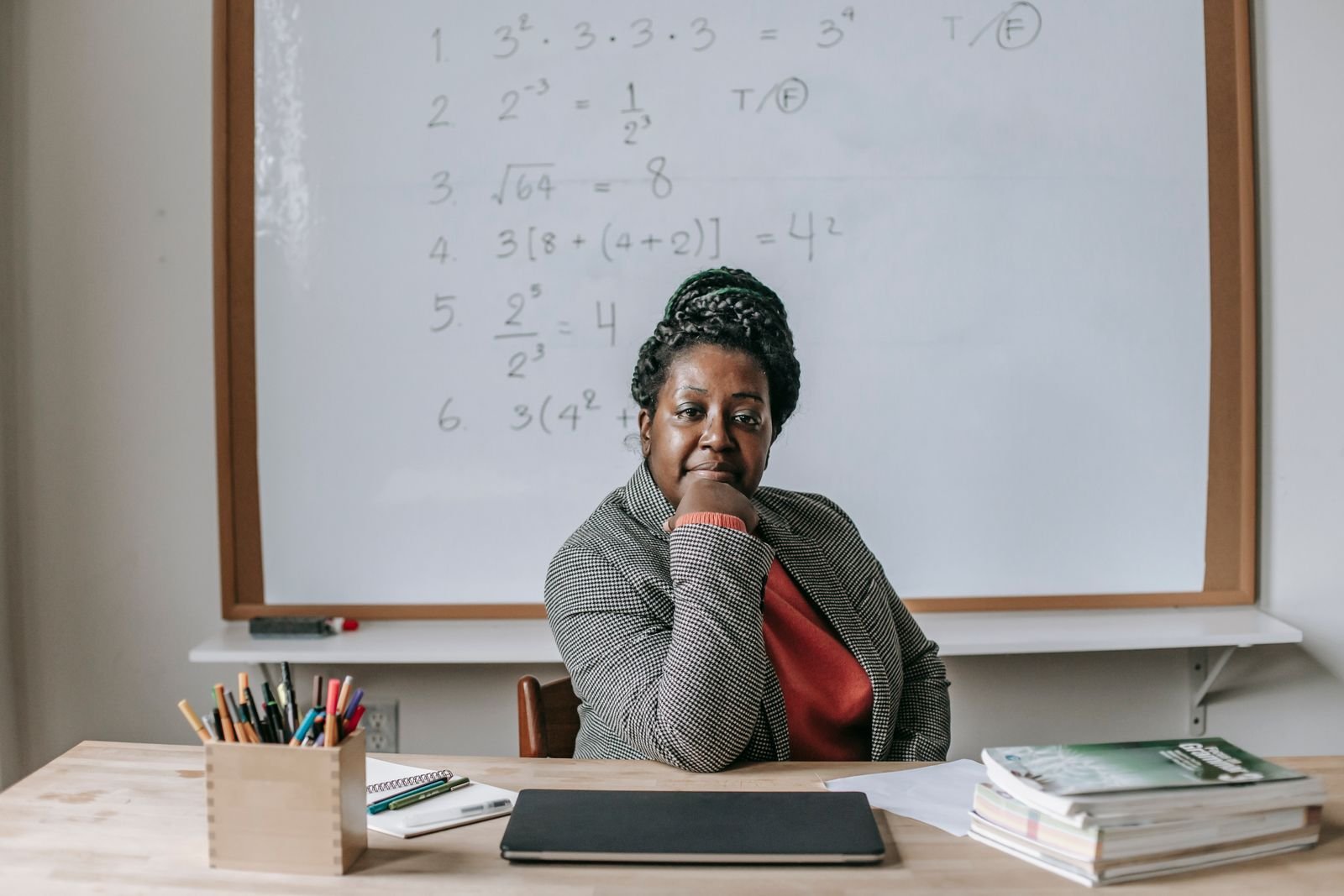 South African Mathematics teacher at her desk in front of a whiteboard