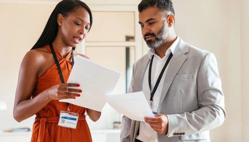 Two professionals reviewing documents together in a workplace